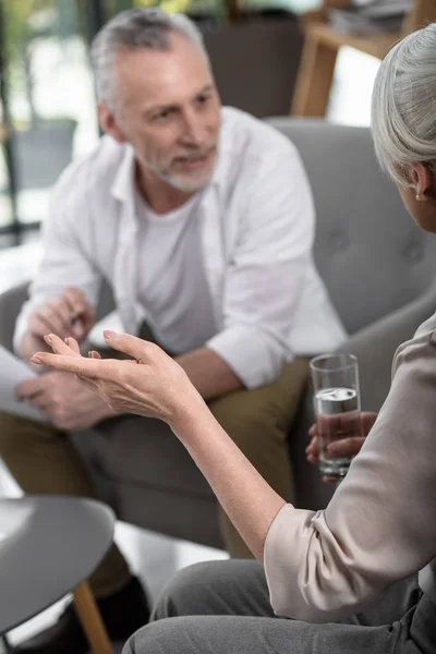 Senior colleagues converse at office — Free Stock Photo