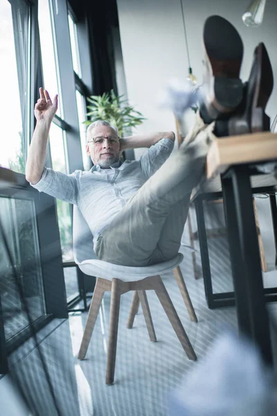 Affärsman som sitter med benen på bordet — Stockfoto