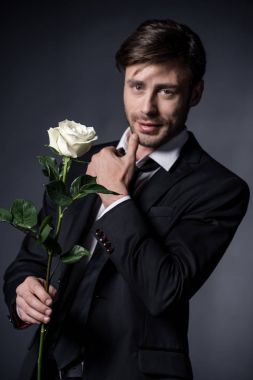man holding rose and looking at camera clipart