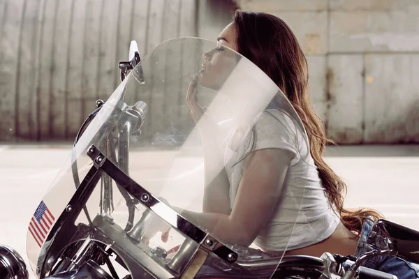 Mujer joven sentada en motocicleta — Foto de Stock