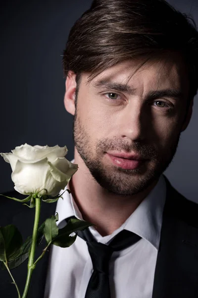 Νεαρός άνδρας στο κοστούμι με άσπρο τριαντάφυλλο — Φωτογραφία Αρχείου