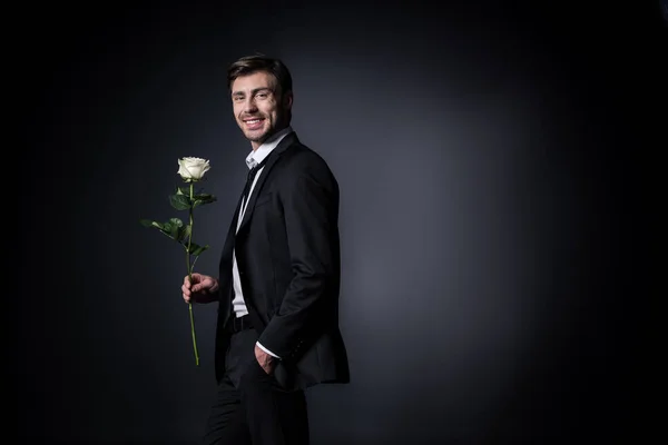 Χαμογελαστός άνθρωπος κρατάει άσπρο τριαντάφυλλο — Φωτογραφία Αρχείου