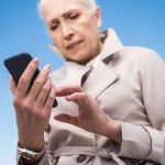 Mulher de cabelos grisalhos usando smartphone