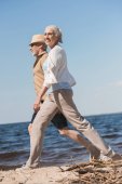 Seniorenpaar geht am Strand spazieren 