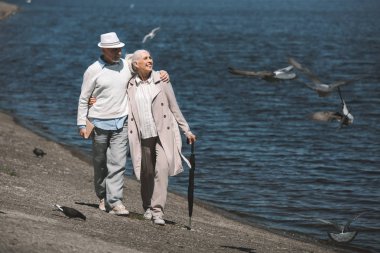 Sahilde yürüyen yaşlı çift. 