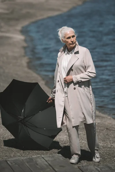 Seniorin mit Regenschirm — kostenloses Stockfoto