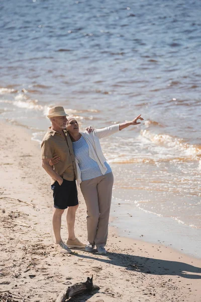 Ηλικιωμένο ζευγάρι περπατά στην παραλία — Φωτογραφία Αρχείου