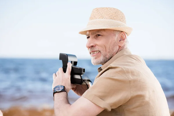 Homem sênior com câmera instantânea — Fotografia de Stock
