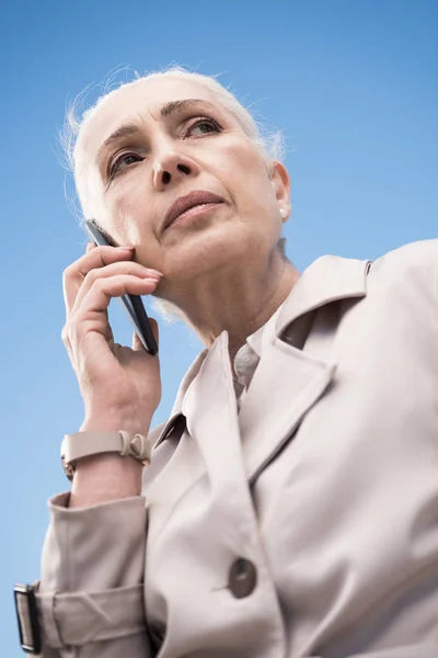 Donna dai capelli grigi che parla su smartphone — Foto stock gratuita