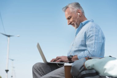 dizüstü bilgisayar açık havada üzerinde çalışan yaşlı adam