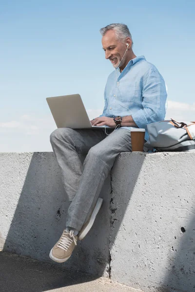Szare włosy człowiek pracuje na laptopie — Zdjęcie stockowe