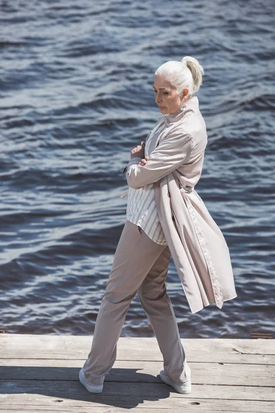 Случайная пожилая женщина позирует на берегу реки — стоковое фото