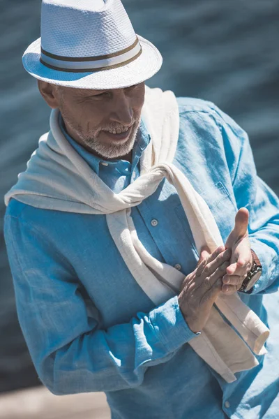 Senior man smiling and rubbing hands — Stock Photo, Image