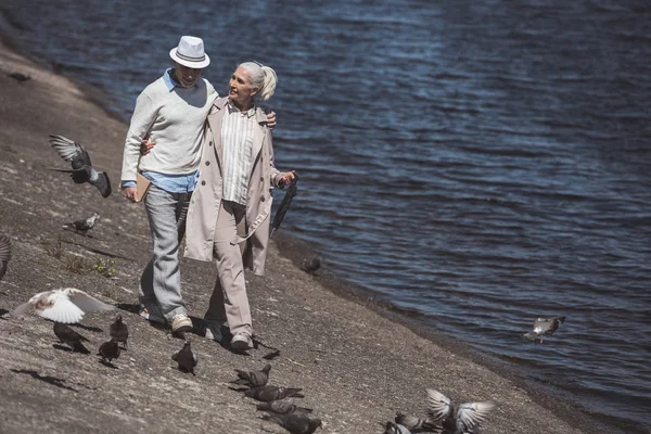 Senior couple walking on river shore — Stock Image Senior couple walking on river shore Stock Image