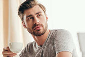 handsome man drinking coffee at home