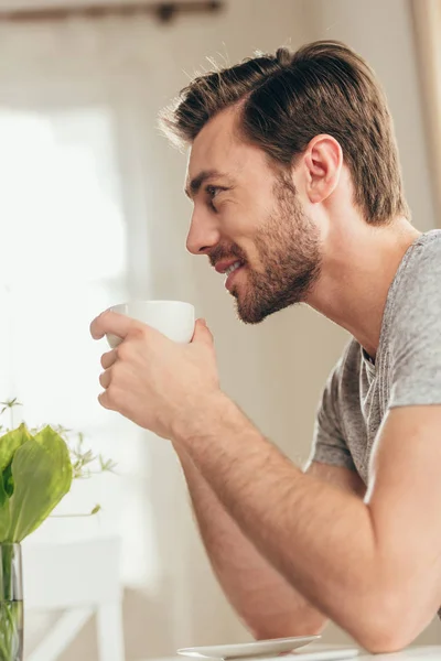 Όμορφος άντρας πίνει καφέ στο σπίτι — Φωτογραφία Αρχείου