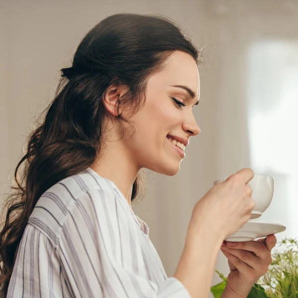 Χαμογελώντας γυναίκα πίνοντας καφέ στο σπίτι — Φωτογραφία Αρχείου