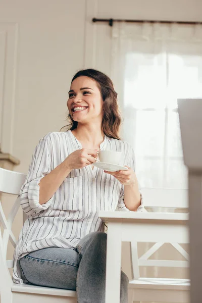 Усміхнена дівчина п'є каву вдома — стокове фото