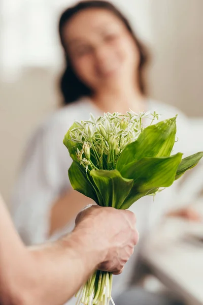 Man presenting flowers to girlfriend