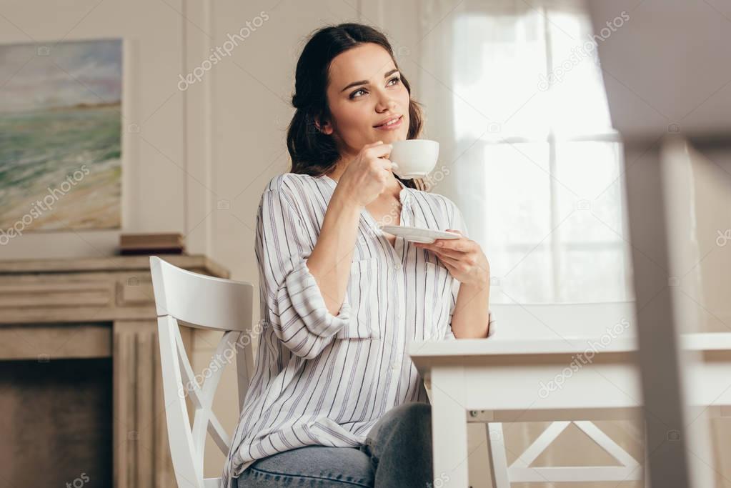 young woman drinking coffee at home