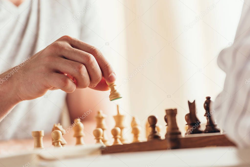 man moving chess figure during game