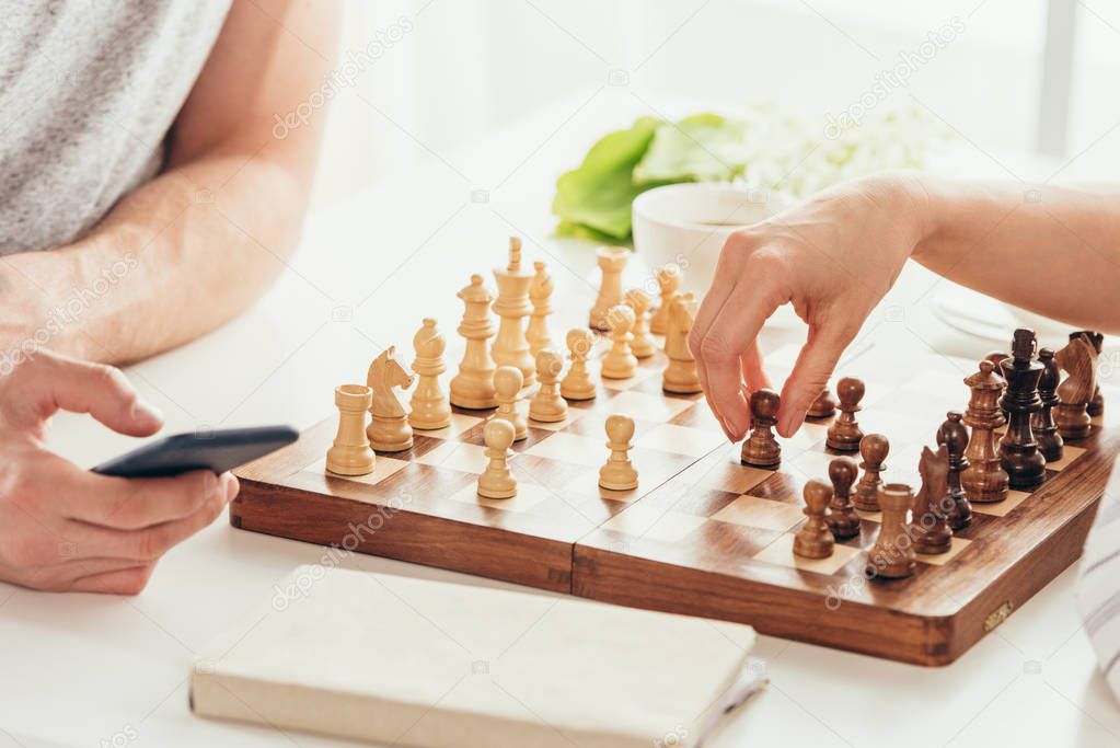 young couple playing chess at home