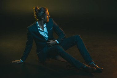 kaykay üzerinde oturan takım elbiseli adam