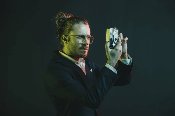 Hombre en esmoquin tomando foto en cámara — Foto de Stock