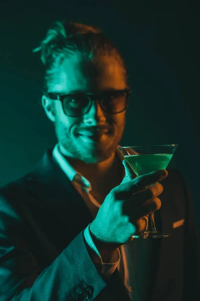 Усміхнений чоловік тримає келих з коктейлем — Безкоштовне стокове фото