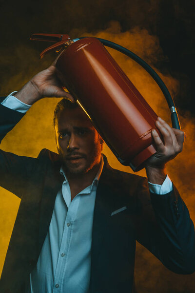 man in suit holding fire extinguisher