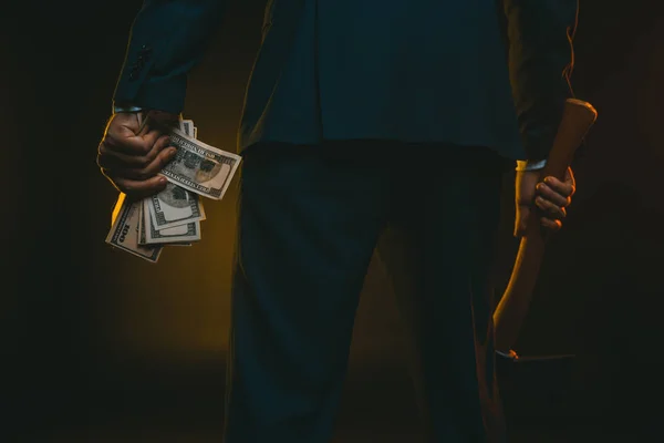 Man holding ax and dollar banknotes — Stock Photo, Image