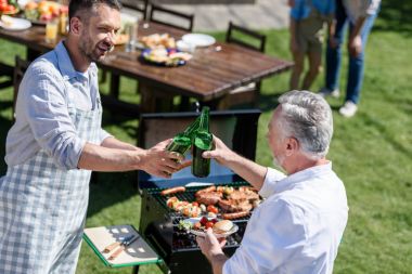 men clinking bottles of beer clipart