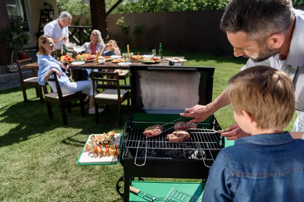 Glückliche Familie beim Grillen — Stockfoto