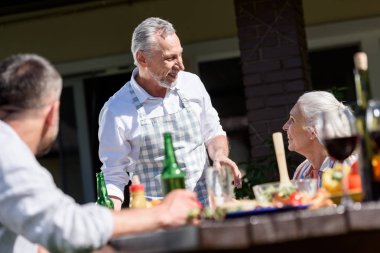 family talking during lunch on patio clipart