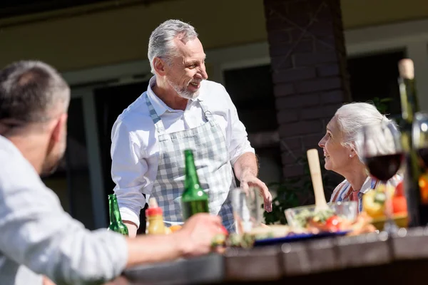 Family talking during lunch on patio — Stock Photo, Image