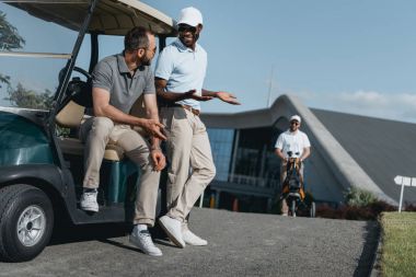 golf arabasında otururken konuşan arkadaşlar 