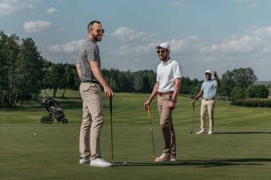 gülümseyen arkadaş golf oynamak