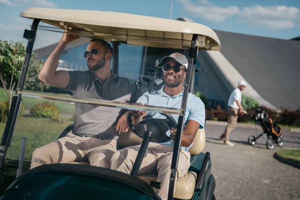 Homens montando carrinho de golfe — Fotografia de Stock