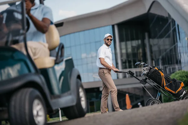 Mannen med golfklubbar i väska — Stockfoto