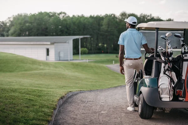 Golfista in piedi vicino golf cart — Foto Stock