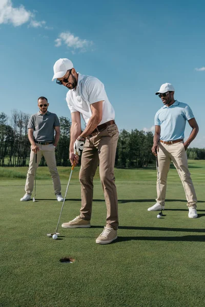 Golfer putting ball into hole — Stock Photo, Image