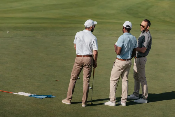 Golfistas profissionais falando em campo verde — Fotografia de Stock