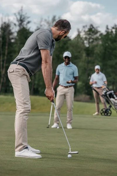 Golfista con el objetivo de golpear la pelota con el club — Foto de Stock