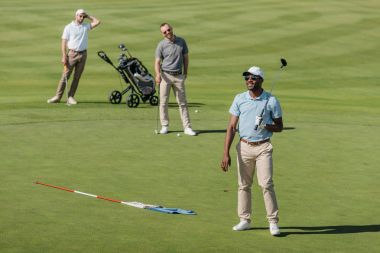 golf kulüpleri sahada ayakta sporcular