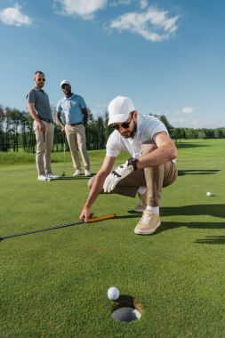 golf oyuncu topu deliğe yakınındaki bakarak