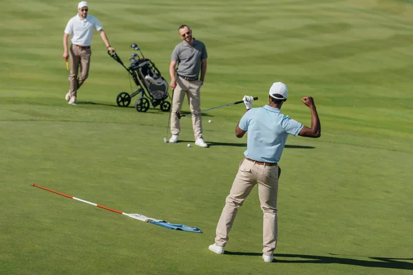 Golfare som firar framgångar med vänner pitch — Stockfoto