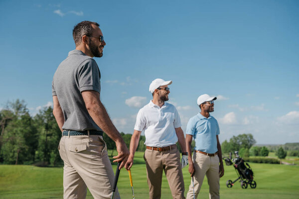 multiethnic golf players looking away