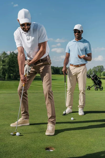 Golfer putting ball into hole — Stock Photo, Image