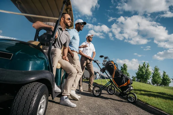 Чоловіки, що стоять біля кошика для гольфу — стокове фото