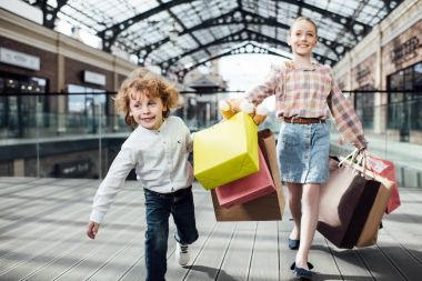 happy children holding shopping bags  